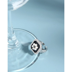 Detail of vintage S925 silver ring with black enamel hexagon and pearl flower