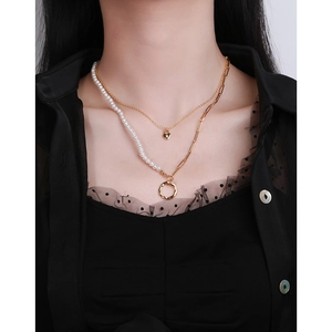 Detailed view of layered S925 silver necklace with gold heart and pearl chain elements