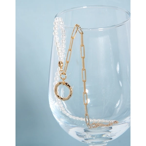 Close-up of S925 silver pearl necklace with hammer-textured gold pendant on glass