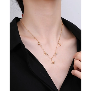 Elegante goldene Schmetterlingshalskette für Damen mit Perlen und Blumen am Modell