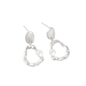 Irregular silver textured hoop earrings with a white pearl in a minimalist style