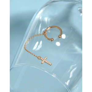 Detail view of gold cross ear cuff with chain and zircons on glass edge