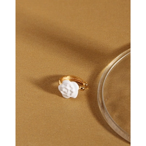 Close-up of golden ear cuff with white camellia flower design for non-pierced ears