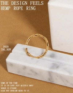 Dettaglio ravvicinato della trama intrecciata dorata su un anello in argento minimalista