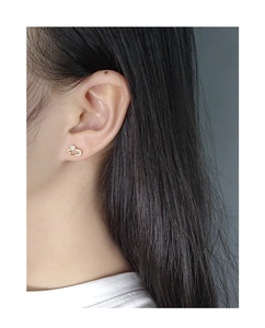 Close-up of minimalist gold safety pin earring with crystals and a small white pearl
