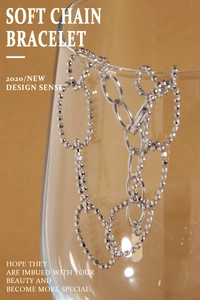 Macro detail of S925 sterling silver soft chain bracelet with textured round beads