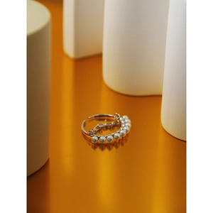 Macro shot of silver pearl chain ring featuring seven white pearls on a geometric stand