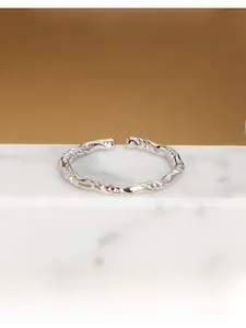 Dettaglio macro dell'anello in argento S925 con trama a corda intrecciata e design aperto