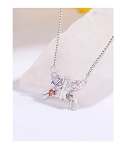 Detail of silver butterfly pendant featuring colorful zircon stones on white crystal rock