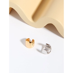 Macro detail of minimalist gold and silver wide ear cuffs with high-polish mirror finish
