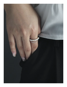Detail of a double-layered S925 silver ring featuring pearls and a sleek metal chain link