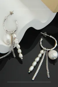 Detail of silver drop earrings with freshwater pearls and long tassel zircon chains