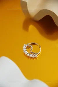 Detailed macro of S925 sterling silver ring featuring seven pearls and a delicate metal chain