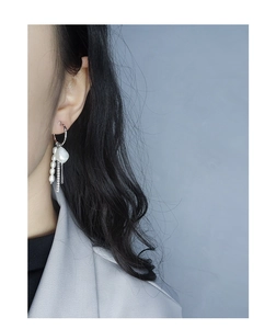 Close-up of S925 sterling silver drop earrings with baroque pearls and tassel chains