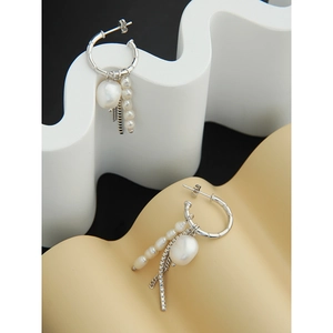 Detailed shot of S925 silver earrings featuring baroque pearls and metallic chain tassels