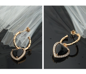 Detailed macro view of S925 silver heart earrings with black agate and crystal accents
