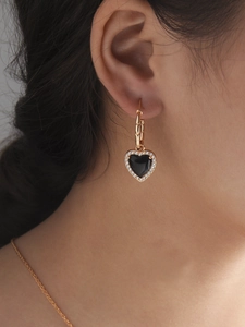 Detail of elegant black heart drop earring with micro-pave crystals on female model