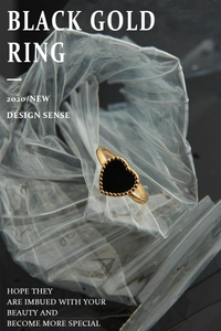 Detailed shot of black gold heart ring with vintage beaded edge and golden band