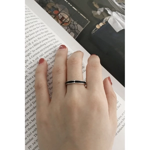 Detail of vintage S925 sterling silver ring with black enamel inlay worn on index finger
