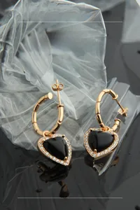 Detailed close-up of S925 silver heart earrings with black onyx and white crystals