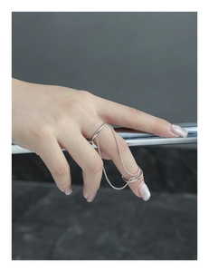 Detail of S925 sterling silver double ring set connected by a delicate metal chain