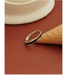 Close-up of S925 sterling silver stamp on minimalist arrow ring with black enamel inlay