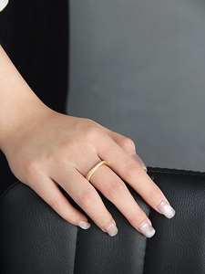 Détail d'une bague en argent s925 plaqué or sertie de pierres scintillantes au doigt