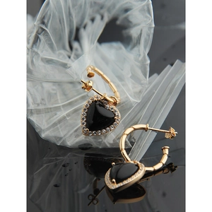 Detail of heart earrings featuring black onyx with gold bamboo texture and pave zircons