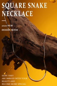 Detailed view of silver square snake bone chain necklace over dark wood and amber background