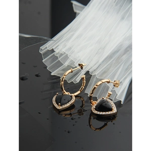 Detail of vintage heart earrings with black onyx and micro-paved crystals on gold base