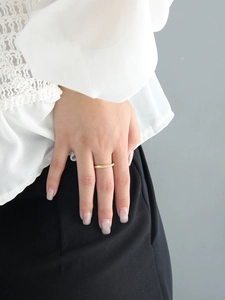 Gros plan d'une bague Mobius en or avec pavé de zircons étincelants sur le doigt