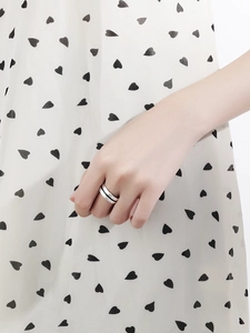 Detail of minimalist S925 silver double layer ring shown on model wearing heart pattern dress