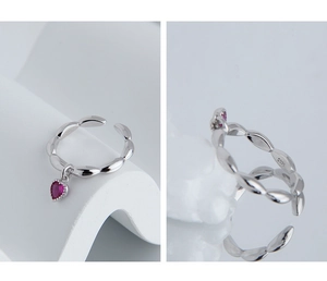 Detail of S925 sterling silver ring with red zircon heart charm and engraved hallmark