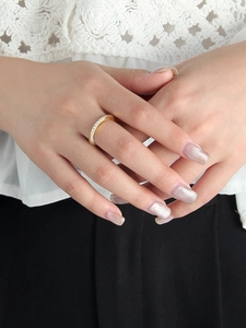 Détail d'une fine bague Möbius dorée avec pavé de cristaux portée sur le doigt