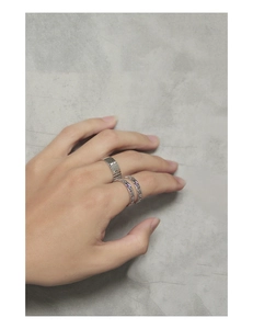 Detail of stacked S925 sterling silver rings with vertical grooves and chain design
