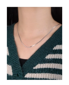 Detail of silver S925 flat snake bone chain necklace worn on neck for daily minimalist look