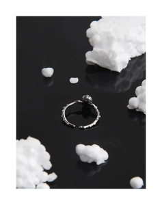 Close-up of S925 sterling silver skull ring with vintage bone texture on black background
