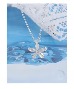 Détail macro du collier avec pendentif fleur en argent 925 et pierre de zircon claire