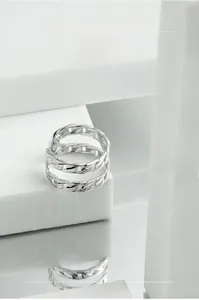 Close-up of S925 sterling silver U-shaped double chain ring on white geometric display