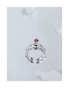 Macro view of adjustable silver leaf band featuring a pink heart-shaped zircon gemstone