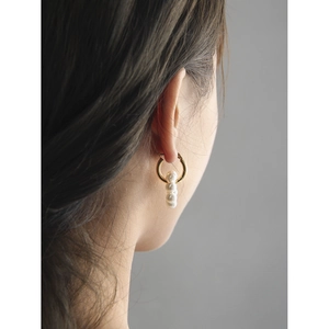 Créoles dorées minimalistes avec trois perles verticales portées par un mannequin