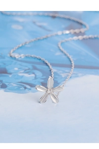 Détail d'un pendentif fleur en argent avec un centre étincelant sur une chaîne délicate