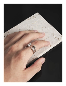 Close-up of a sterling silver liquid-style ring with artistic sphere stacking design