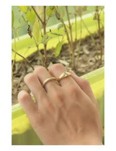Detail of stacked gold rings with a heart-shaped zircon stone and pave-set crystals