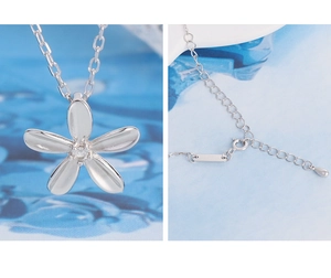 Détail du pendentif fleur argentée avec diamant central et chaîne à fermoir mousqueton