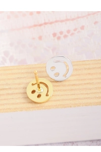 Detail of silver and gold hollow smiley face stud earrings on a rustic wood background