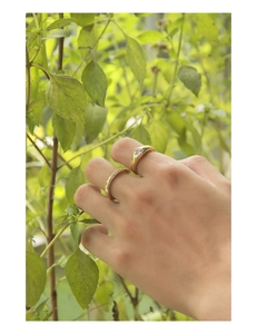 Close-up of a stacked gold ring set with heart-shaped zircon on a finger