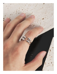Macro view of minimalist irregular liquid metal S925 silver ring on travertine stone