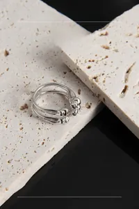 Detailed view of S925 sterling silver double-layered open ring on a textured stone surface