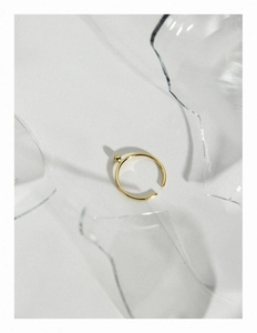 Détail d'une bague minimaliste en argent S925 avec perle dorée et reflets de verre